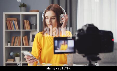 Female vlogger testing wireless headphones Stock Photo