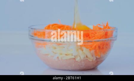 Girl is preparing minced meat. The female hand adds carrot, onion, egg to the cooked minced meat and mixes. Meat dishes Stock Photo
