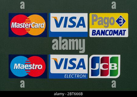 Logos of accepted credit cards displayed in front of door to a store Stock Photo