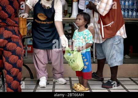 Covid-19 child.  Free food handout to people in need due to loss of income from Coronavirus funded by local businesses in Pattaya Thailand Asia Stock Photo