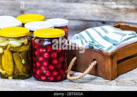 Jars with variety of canned vegetables and fruits, jars with zacusca. Preserved food concept in a rustic composition. Stock Photo