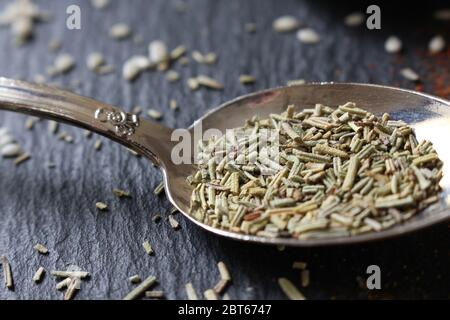 A teaspoon of dried herbs on a slate background.  Raw ingredients for cooking Stock Photo