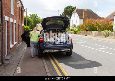 Ashford, Kent, UK. 23rd May, 2020. Friends and neighbours in the village of Hamstreet near Ashford in Kent occupy their time with chores about the house. Ashford borough council has announced that the local tip is to open with pre-booked timeslots, this woman loads up her car before heading there for her allocated time. ©Paul Lawrenson 2020, Photo Credit: Paul Lawrenson/Alamy Live News Stock Photo