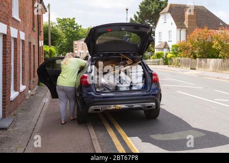 Ashford, Kent, UK. 23rd May, 2020. Friends and neighbours in the village of Hamstreet near Ashford in Kent occupy their time with chores about the house. Ashford borough council has announced that the local tip is to open with pre-booked timeslots, this woman loads up her car before heading there for her allocated time. ©Paul Lawrenson 2020, Photo Credit: Paul Lawrenson/Alamy Live News Stock Photo