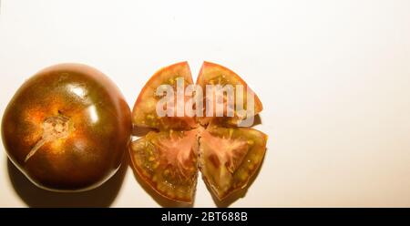 Fresh Pair Of Kumato Tomatoes One Of Them Open In Half And Chopped On White Background Stock Photo
