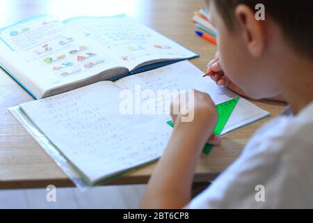 A child does homework on isolation. Homework. Stock Photo