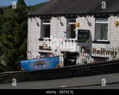 The Railway pub, Marsden with both 'TO LET' and 'NHS / KEY WORKER THANK YOU' signs during the Coronavirus (COVID-19) pandemic. Stock Photo