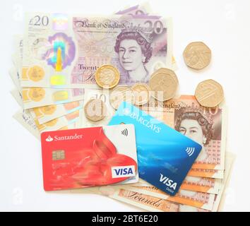 British pound notes, debit cards and coins on white background Stock Photo