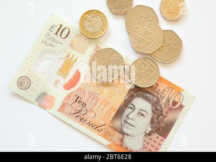 Ten 10 British pounds note and coins on white background Stock Photo