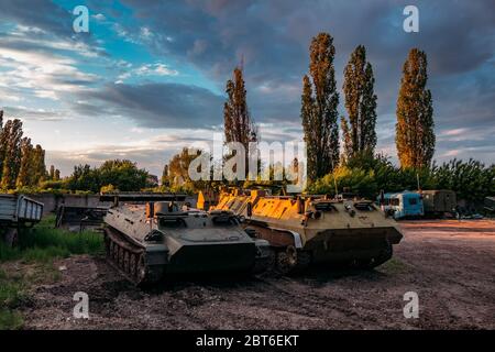 Old Russian armored vehicles on sunset background at military base. Stock Photo