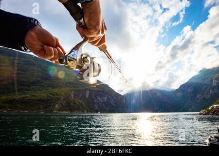 Woman fishing on Fishing rod spinning in Norway. Fishing in Norway is a way to embrace the local lifestyle. Countless lakes and rivers and an extensiv Stock Photo