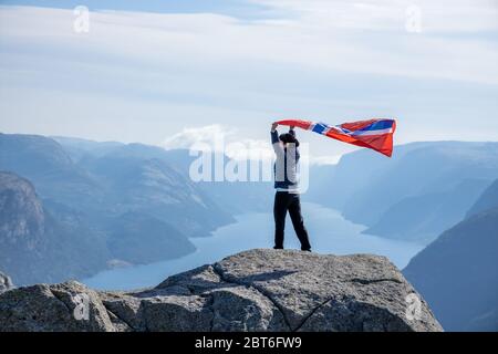 Woman with a waving flag of Norway on the background of nature Stock Photo