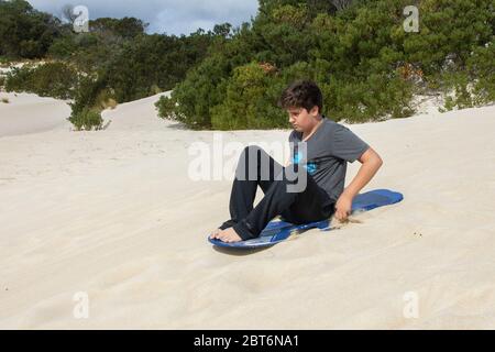 Kangaroo Island, Australia - March 9th, 2020: A teenager sand surfing in Kangaroo Island, Australia. Stock Photo