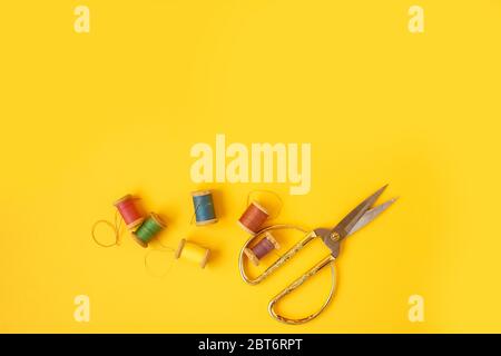Colored coils with threads on a yellow background. Handicrafts and sewing. Stock Photo