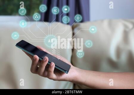 Mobile phone with communication icon floating above. Stock Photo