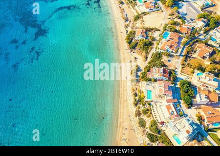 Aerial view of Coral Bay beach - popular beach with clear sea water and comfortable sandy beach, many tourists, sunbeds with umbrellas in Peyia villag Stock Photo