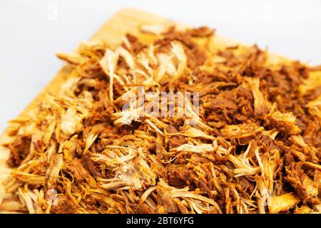 Homecooked pulled pork served shredded on a wooden board. The dish has been prepared in a slow cooker and cooked for nine hours. Stock Photo