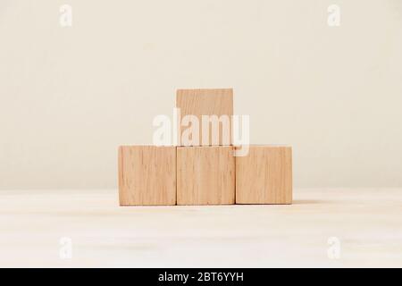 Wooden cube four pieces stacked on the floor. Stock Photo