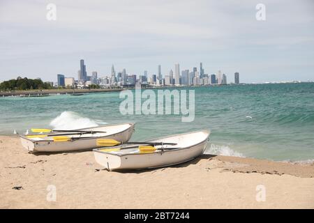 Chicago lakefront skyline including views of Lake Michigan, Chicago beaches, with two row boats sitting on the beach Stock Photo