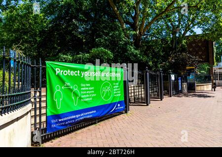 21 May 2020, London, UK - Sign on the gates to Victoria Embankment Gardens reminding people with keep a 2 metre distance and to follow government guidance on preventing the spread of Coronavirus during the pandemic lockdown Stock Photo