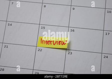 Interview on monthly Calendar and marked 15th isolated on office desk Stock Photo