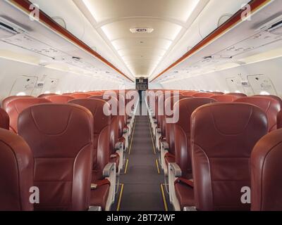 Empty interior cabin of an Airbus A320 Neo with red seats and trim. Many airlines face dire straits as they face a worldwide shutdown of travel due to Stock Photo