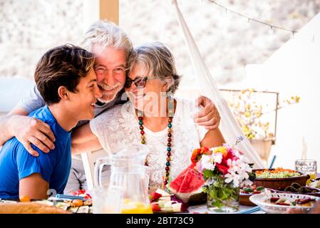 Cheerful caucasian family together with happines - concept of grandfathers and grandson mixed age generations from teenager to senior people with food Stock Photo