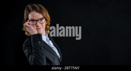 woman looking through glasses. portrait of a young business woman. banner with copy space on a black background Stock Photo