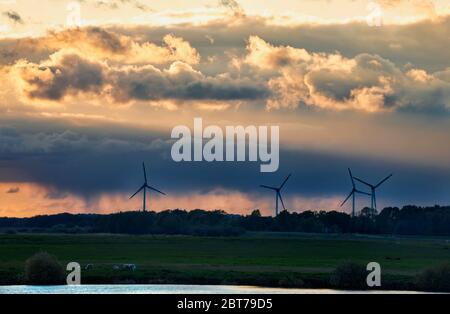 turbines and dranatic rainy sky at sunset, Oldenburg Stock Photo