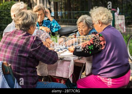 Beijing / China - October 4, 2015: Elderly women playing Mahjong game in the street in Beijing, China Stock Photo