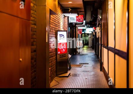 Kyoto, Japan - April 16, 2019: Back street of narrow Pontocho alley downtown district at night by izakaya restaurants signs in dark evening Stock Photo