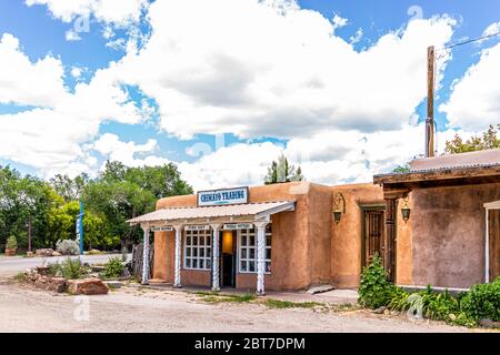Ranchos de Taos, USA - June 19, 2019: Famous St Francic Plaza in New Mexico with Taos trading post store selling souvenirs chimayo sign Stock Photo