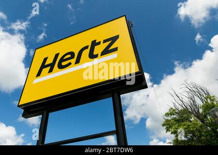 A logo sign outside of a Hertz car rental location in Silver Spring, Maryland on May 23, 2020. Stock Photo