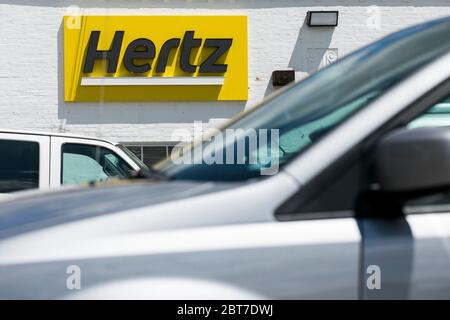 A logo sign outside of a Hertz car rental location in Silver Spring, Maryland on May 23, 2020. Stock Photo