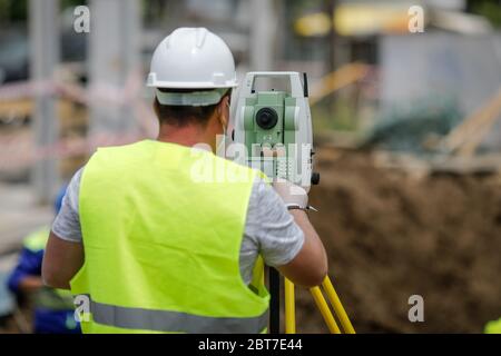 Bucharest, Romania - May 8, 2020: Topography engineers on a construction site with protective masks due to the Covid-19 outbreak. Stock Photo