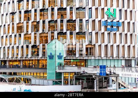 Osaka, Japan - April 13, 2019: Modern building near JR train station in downtown Japanese city with sign for Hanshin shopping mall department store Stock Photo