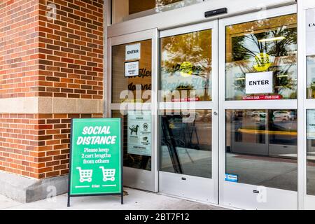 Herndon, USA - May 21, 2020: Sprouts Farmers Market sign for grocery store entrance for social distancing saying please keep two carts distance or six Stock Photo