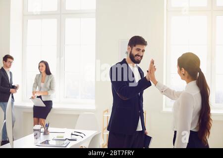 Business people workers give a five hand happy smiling successful project at workplace in modern office. Stock Photo