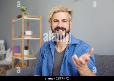 Young hipster guy looking at the camera online talks at a meeting training communication conference video chat education webinar call application. Stock Photo