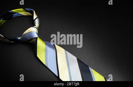 Men's striped tie in different colors isolated on black background. Stock Photo
