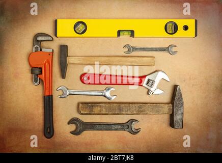 Various tools to work with, hammer, spanner, gas wrench, level to measure the level. Close-up on a background of craft paper Stock Photo