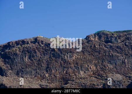 little houses on a big cliff under a perfect blue sky Stock Photo