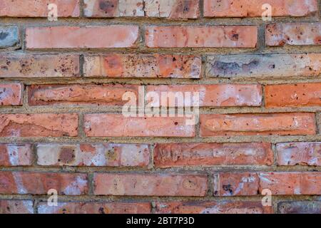 Old red brick wall with cracks, rzhachina and stains. Destruction of the masonry facade of an antique building. Close-up Stock Photo