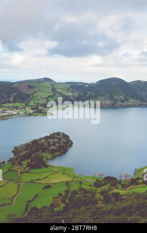 Amazing view of the Lagoa Azul and village Sete Cidades from the Miradouro do Cerrado das Freiras viewpoint in Azores, Portugal. Lakes surrounded by green fields and forest. Vertical photo. Stock Photo
