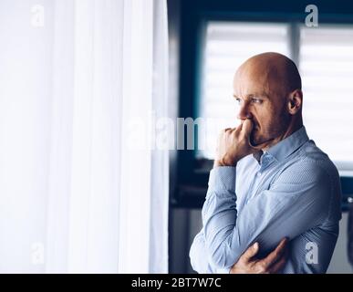 Worried businessman in office. Thoughtful man looking through the window. Stock Photo