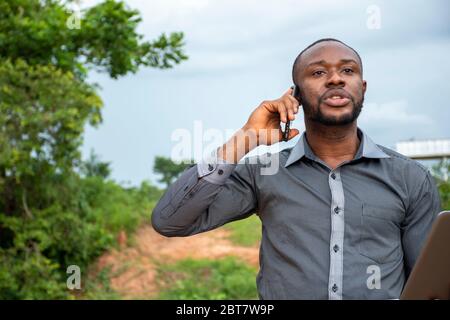 young african business man making a phone call, looking worried Stock Photo