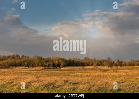 Early spring sunset rural landscape with river Ros and dramatic clouds, Ukraine. Stock Photo