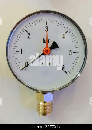 Pressure measuring industrial instrument closeup on a white background. Stock Photo