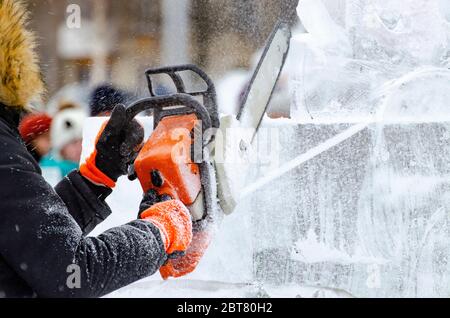 Man creating ice figure chainsaw Stock Photo