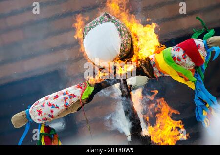 Burning effigies straw Maslenitsa in fire on traditional slavic national holiday Shrovetide. Stock Photo